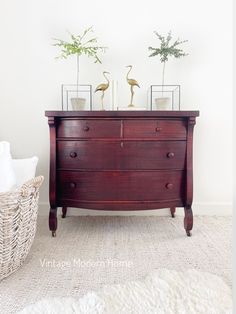 a dresser with two plants on top of it