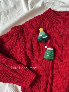 a red sweater with a christmas tree on the front and two small trees on the back