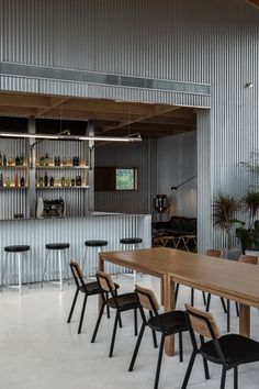 an empty restaurant with chairs and tables in front of a bar area that has bars on the wall