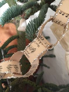 a christmas tree with sheet music on it's ribbon hanging from the top of it