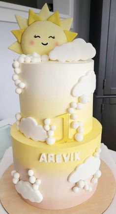 a three tiered cake with white frosting and yellow icing