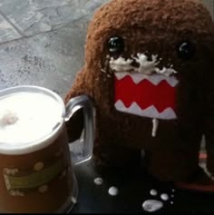 a stuffed animal next to a cup of coffee