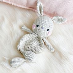 a crocheted bunny laying on top of a white blanket