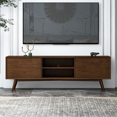 a large flat screen tv mounted to the side of a wooden entertainment center in a living room