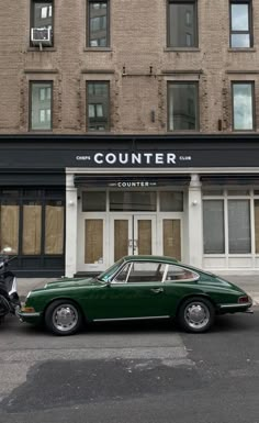 a green car parked in front of a building