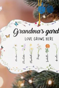 an ornament hanging from a christmas tree that says grandma's garden love grows here