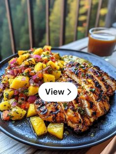 grilled chicken with pineapple salsa on a plate next to a glass of beer