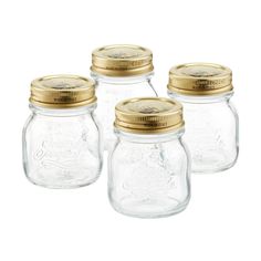 four glass jars with gold lids