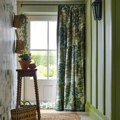 a room with green walls and floral curtains