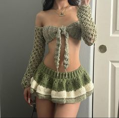 a woman wearing a green and white crochet skirt with her hand on her hip