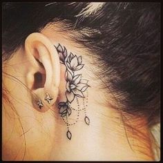 a woman's behind the ear tattoo with flowers