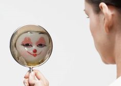 a woman holding a magnifying glass with a clown face on it's side