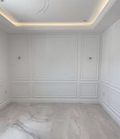 an empty room with white walls and marble floors