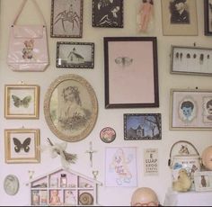 there is a wall with many pictures on it and a doll house in the middle