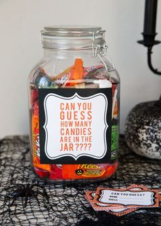 a jar filled with candy sitting on top of a table next to a halloween decoration