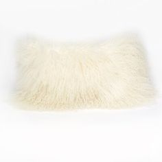 a white furry pillow sitting on top of a table