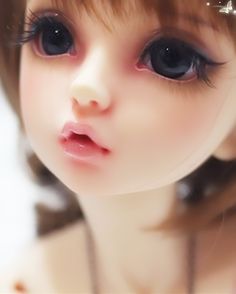 a close up photo of a doll with blue eyes