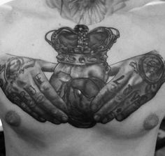 a man's chest with two hands and a crown on it