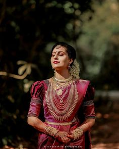 a woman in a red and gold outfit with her hands on her hips looking up