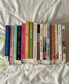 a row of books sitting on top of a bed