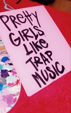 a piece of paper that says pretty girls like trap music next to a plate with paint on it