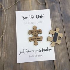 two pieces of wooden puzzle sitting on top of a piece of paper with the words save the date