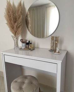 a white vanity table with a mirror and stool