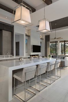 an image of a modern kitchen setting with white countertops and grey bar stools