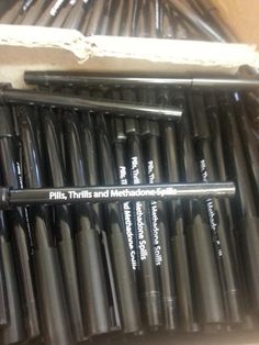 there are many pens in the box and one is on top of another set of pens