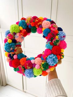 How To Make A Pompom Christmas Wreath using yarn and no special tools. Easy Christmas DIY projects for adults Pompon Wreath Diy, Yarn Holiday Decor, Diy Christmas Pom Pom Garland, Pom Pom Christmas Tree Decorations, Pompon Christmas Decoration, Pompom Wreath Christmas Diy, Diy Pompom Wreath, Pompon Wreath Christmas, Pompom Wreath Tutorial