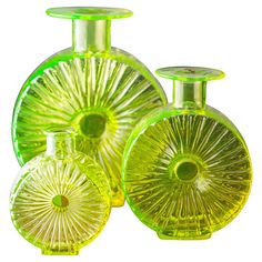 three green glass vases sitting next to each other