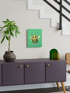 a plant sitting on top of a purple cabinet next to a stair case in a living room