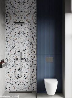 a white toilet sitting next to a blue wall in a bathroom under a faucet