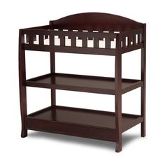 a wooden baby crib with candles on the top and bottom shelf in dark brown