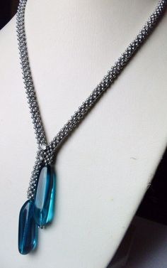 a necklace with blue glass beads on a mannequin