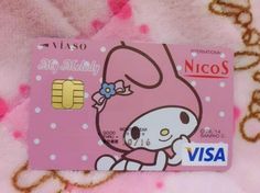 a hello kitty credit card sitting on top of a pink blanket