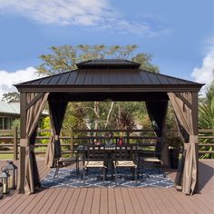 a gazebo on a deck with chairs and tables