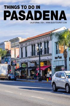 a car driving down the road in front of buildings with palm trees on both sides