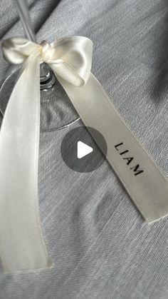 a white ribbon is tied around the collar of a gray shirt with an i am written on it