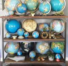 an assortment of globes on shelves in a room