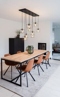 an image of a dining room table and chairs with lights hanging from the chandelier