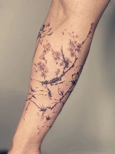 a person's leg with tattoos on it and flowers in the middle of their legs