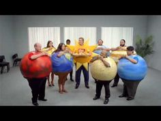 a group of people standing around each other holding giant balls