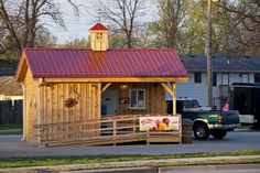 a small wooden building with a red roof