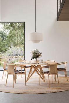 a dining room table and chairs in front of a large window