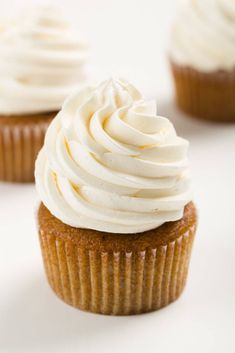 three cupcakes with white frosting on top