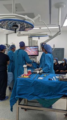 medical personnel in scrubs and surgical gowns operating on an operation table at the hospital