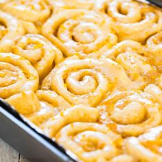 a pan filled with cinnamon rolls covered in icing