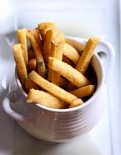 a white bowl filled with french fries on top of a table