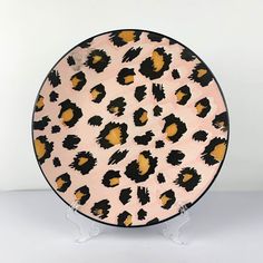 a pink and black leopard print plate on a stand